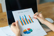 © jannoon028 - Business woman hand with Financial charts and laptop on the tabl