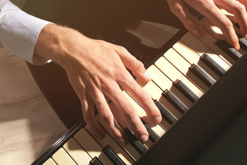 Wall Mural - Man hands playing piano, close up