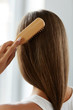 © puhhha - Back View Of Woman With Healthy Long Hair Brushing It With Brush
