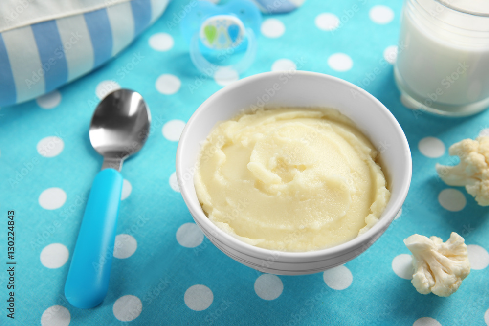 Bowl with healthy baby food on table. Child feeding concept