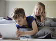 © Mint Images - Brother and  sister looking at digital tablet