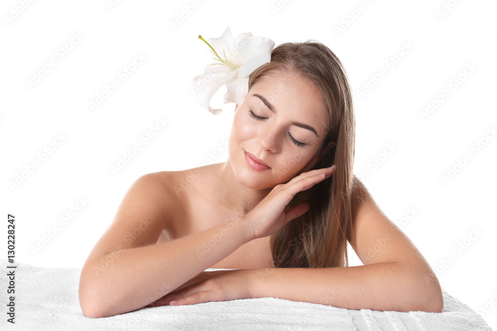 Beautiful young woman lying on towel on white background