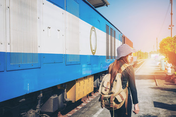 Traveler woman walking and waits train on railway platform