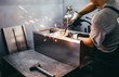© hedgehog94 - Factory for production of heavy pellet stoves and boilers. Close up shot of manual worker's hand welding some parts.