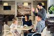 © romankosolapov - family, parenthood, technology, people concept - happy mother, father and little girl having dinner asked waiter to take picture by smartphone