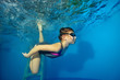 © alexbard - Sports little girl swims underwater in the pool on a blue background. Portrait. Shooting underwater. Landscape orientation