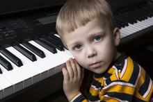 Dreaming Little Boy Sitting At The Piano