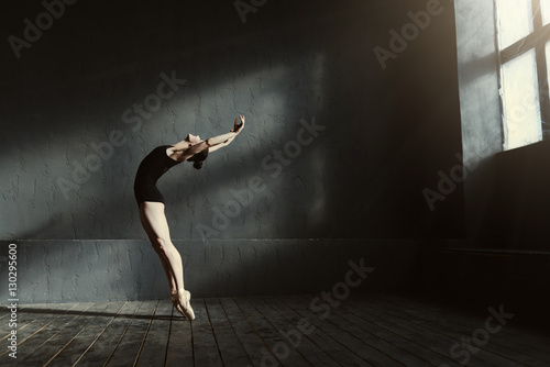 Fotografie, Obraz Flexible ballet dancer stretching in the dark lighted studio
