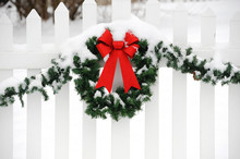 Christmas Wreath On The White Fence After Snow