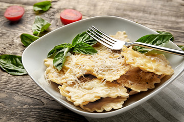 Canvas Print - Plate of ravioli with cheese on table