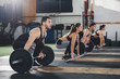 Athletes lifting barbells at gym
