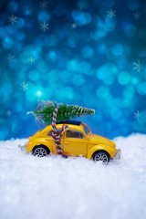 Christmas concept with miniature car toy carrying a Christmas tr