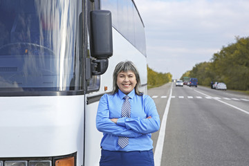 Female  driver standing in front of bus