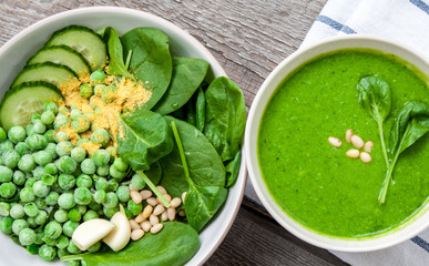 Wall Mural - Green peas spinach basil pesto and Ingredients in a white bowl on a wooden background. Love for a healthy raw food concept.