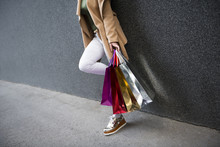 Shopping Time! Unrecognizable Woman In White Pants Holding Multi Colored Shopping Bags!