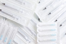 New Syringes And Needles Lie On The Surface, Packed In Bags.