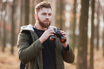 Poster - Concentrated serious bearded man holding field-glass