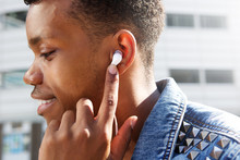 Attractive Man Listening To Music With Finger To Ear