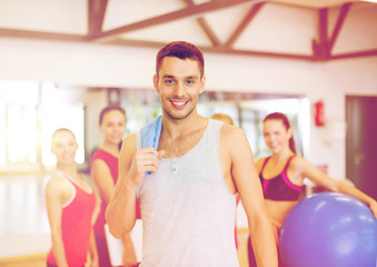 Canvas Print - smiling man standing in front of the group in gym