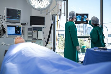 Aufkleber - Surgeons discussing x-ray while operating patient