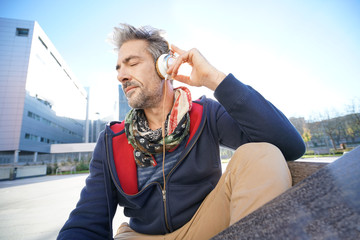 Wall Mural - Skateboarder listening to music with smartphone and headphones