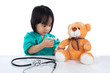 Leinwandbild Motiv Asian Chinese little doctor girl giving injection to teddy bear
