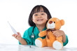 Leinwandbild Motiv Happy Asian Chinese little girl examine teddy bear with thermome