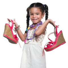 Cute african american small girl dressed up as an adult woman carrying a pair of red shoes