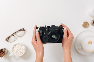 Vintage photo camera being in hands of a female photographer