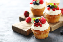Tasty Cupcakes With Berries On Grey Table