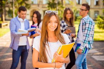 Canvas Print - happy cute girl standing near university and holding notebook