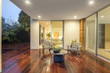Wooden deck / balcony at night with furniture and open doors lea