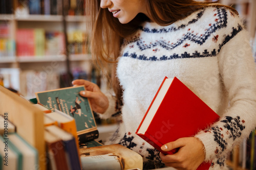 Photographie Young woman choosing books in library