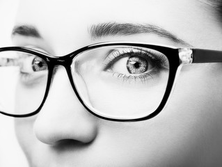 Beautiful young woman wearing glasses close-up isolated on white