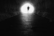 light at the end of the tunnel with silhouette of man