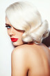 Portrait of young beautiful platinum blonde tanned woman with vintage hairdo and red lipstick