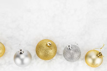 Gold And Silver Christmas Baubles Isolated Against White
