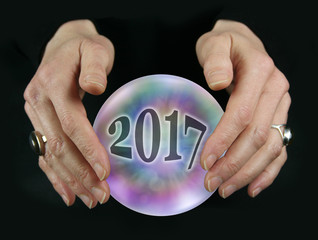 Wall Mural - What will 2017 bring - Crystal Ball reading showing a 2017 inside a colorful translucent crystal ball between female hovering hands on a black background