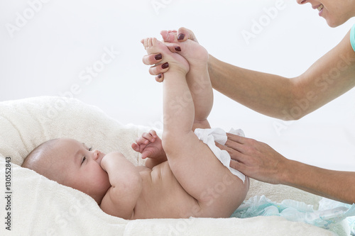 Plakat Matka sprząta pośladki swojego dziecka mokrymi chusteczkami.