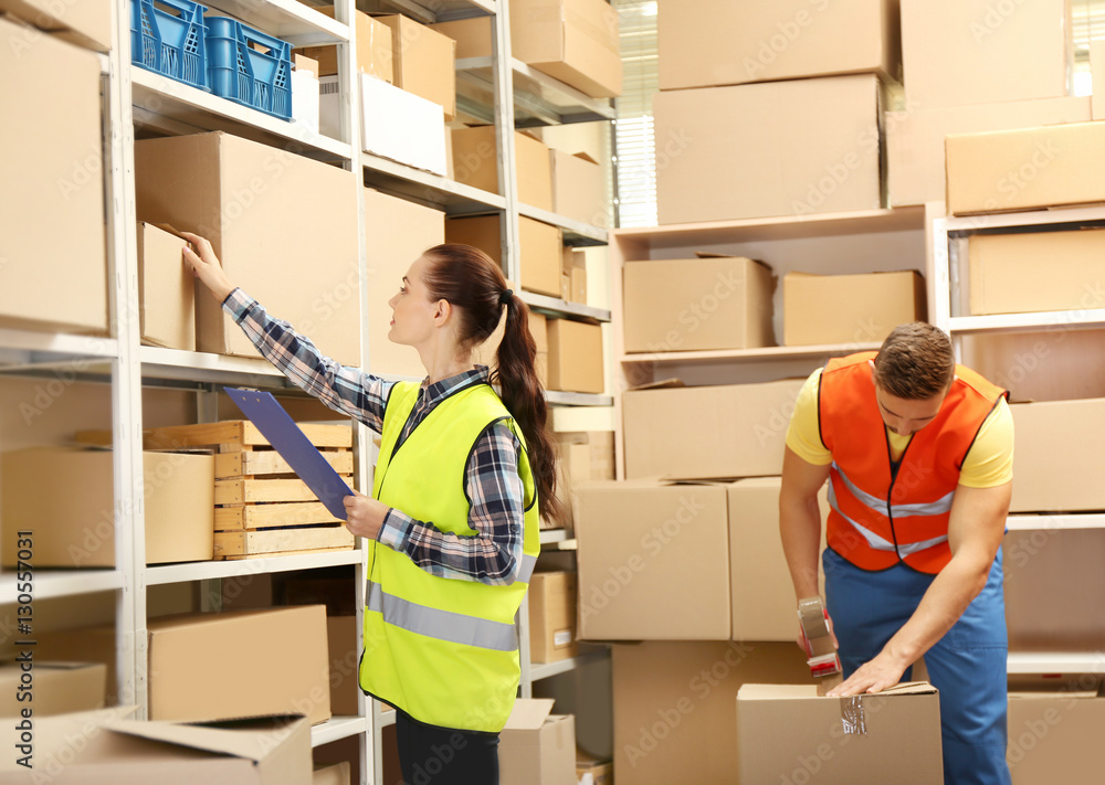 Young businesswoman with clipboard at warehouse