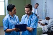 © WavebreakMediaMicro - Male and female nurse having discussion over clipboard in ward