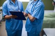 © WavebreakMediaMicro - Mid section of nurses discussing over clipboard