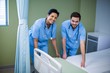 © WavebreakMediaMicro - Portrait of male and female nurse preparing bed for patient