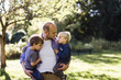 © Cavan Images - Man carrying sons while standing in park