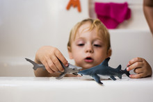 Boy Playing With Toys While Sitting In Bathtub