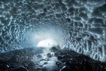 Distant View Of Man Standing In Ice Covered Cave