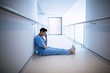 © WavebreakMediaMicro - Tensed female nurse sitting in corridor