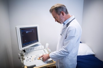 Wall Mural - Doctor using patient monitoring machine in ward