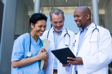 Wall Mural - Surgeons and nurse having discussion on digital tablet