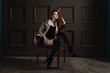 © Petro - The red-haired girl posing on a chair, her gaze beckons, she flirts.